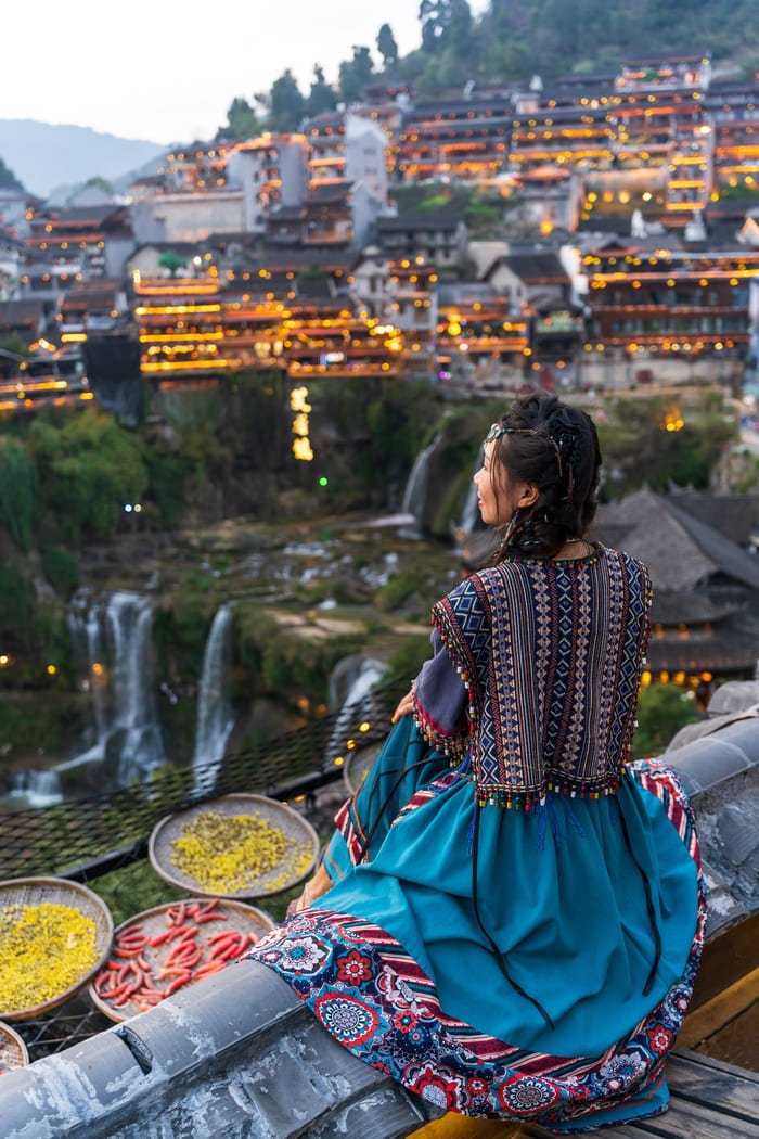 mujer mirando paisaje con casas tradicionales